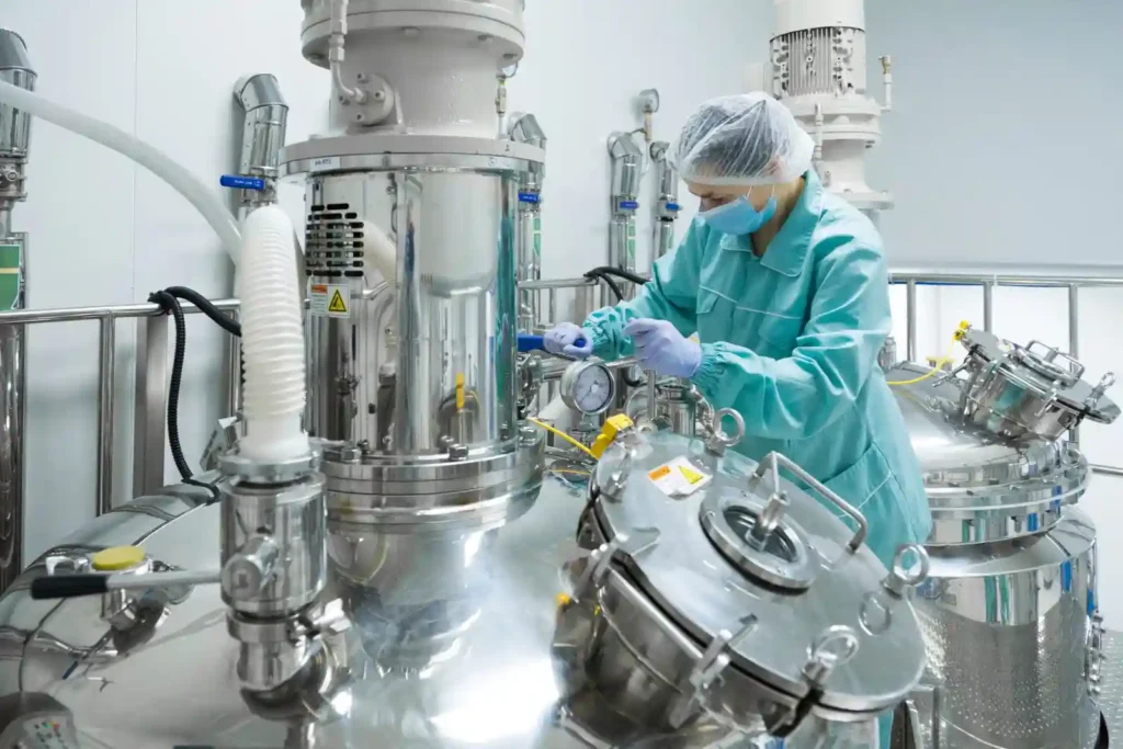 pharmaceutical-factory-woman-worker-protective-clothing-operating-production-line-sterile-environment-scaled